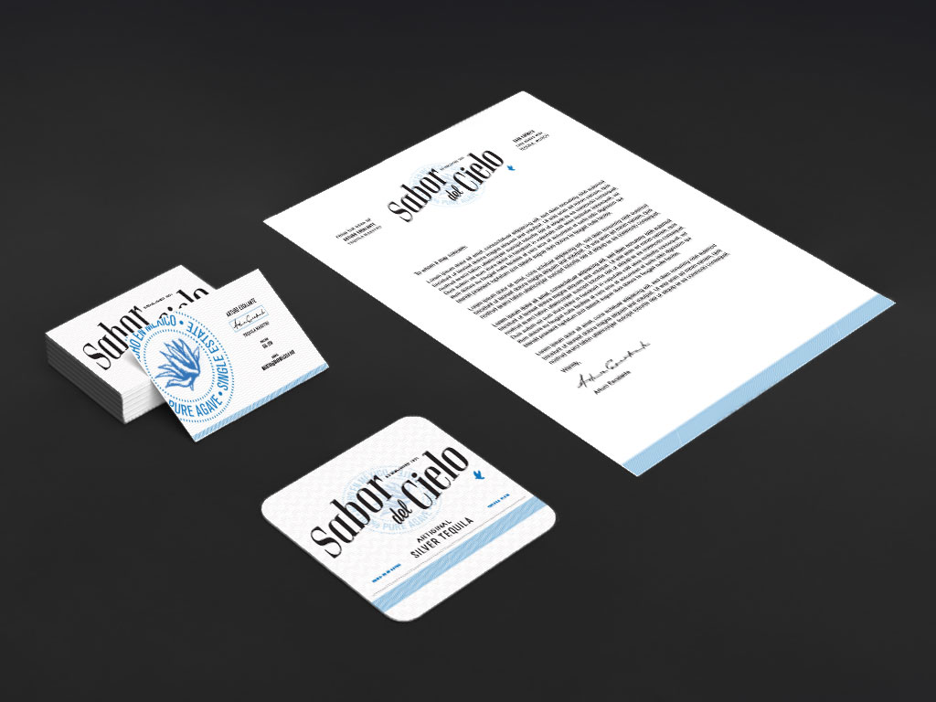 A stationery set for Sabor del Cielo shown at an angle including business cards, a coaster, and a letter.
